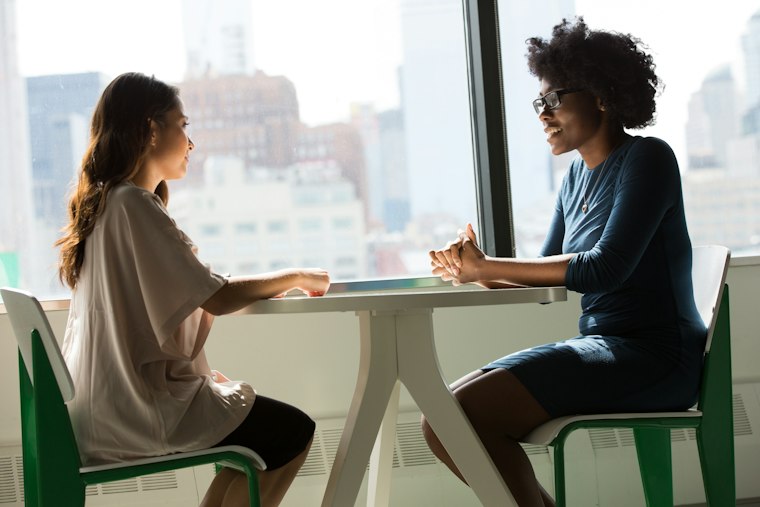 Two colleagues in conversation at a table